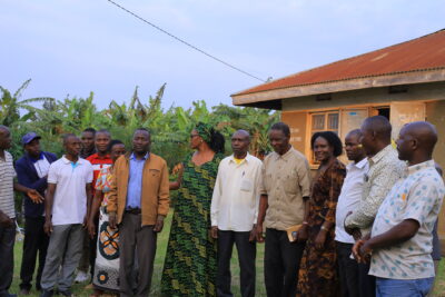 The state minister for primary health care in the middle putting on a kitenge [green color] 